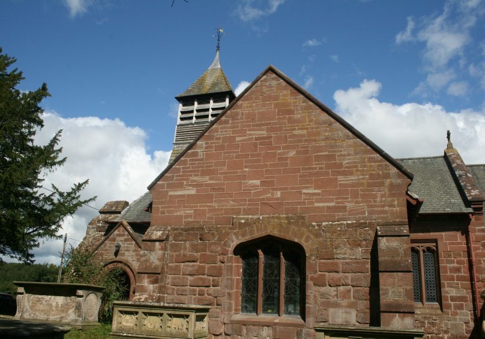 St Mary, Bruera, Cheshire south transept Red stone church showing Lady Chapel and table tombs in churchyard