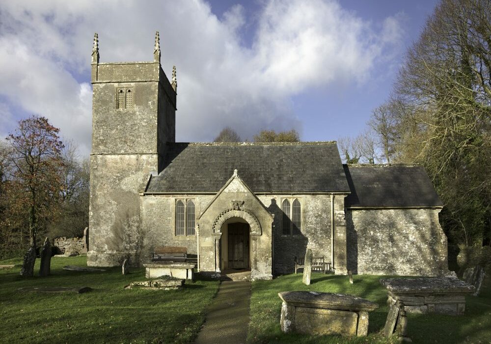 Holcombe Old Church, Somerset exterior Main entrance to old church with tower, table tombs in churchyard