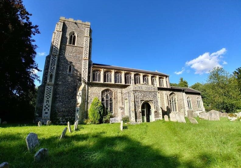 ChurchImages Suffolk Wetheringsett Exterior A sunlit church with decorative flint patterning on the buttresses. There are tall, perpendicular windows in the clerestory