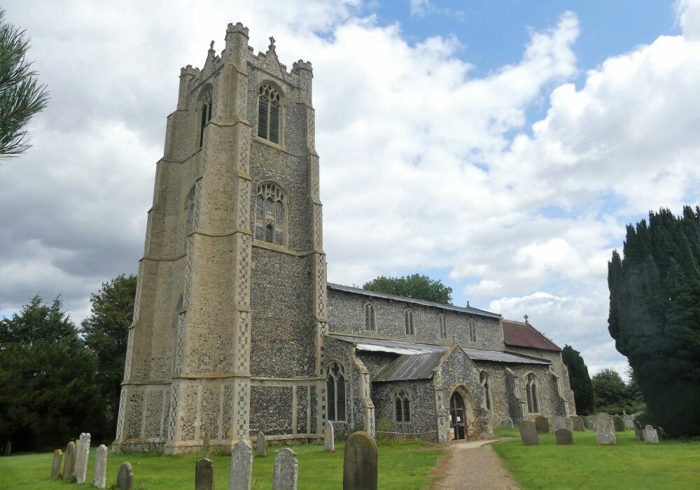ChurchImages-Norfolk Deopham Exterior A huge tower topped with turrents, buttresses at each corner and checkered flint flushwork