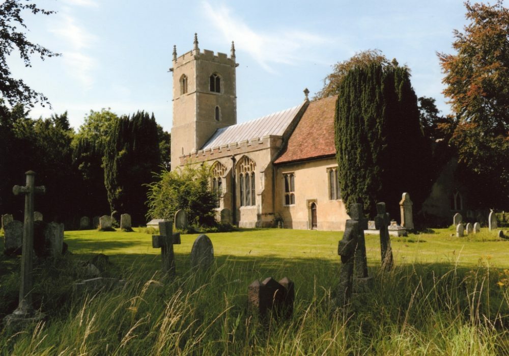 Exterior of a church, in a graveyard, with a square tower, lead roof and large perpendicular windows