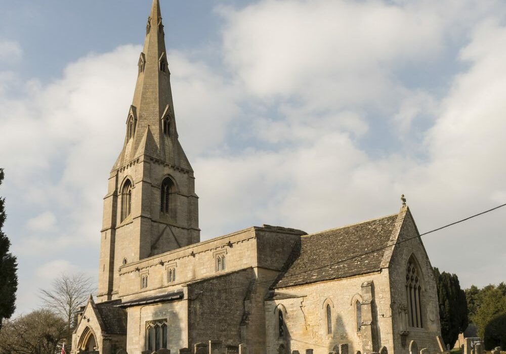 Exerior of stone church with spire, showing south aisle, porch and chancel
