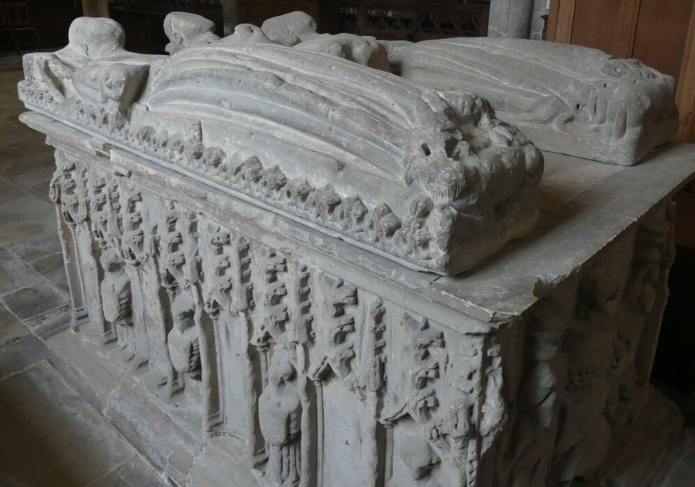 ChurchImages-Lincs Rippingale Double Tomb A tall, stone, table tomb with niches and figures around the side and two carved lying effigies on top
